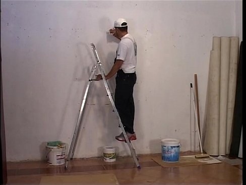 Sexy construction worker girl painting the walls